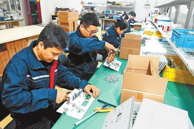 員工在生產(chǎn)車間裝配工業(yè)產(chǎn)品